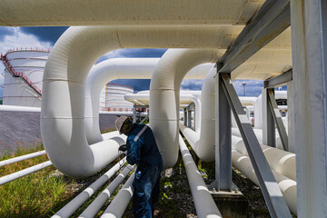 Male worker inspection ultrasonic thickness at steel long pipes and pipe elbow in station oil factory during refinery valve of visual