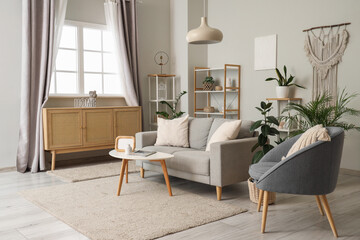 Interior of living room with sofa, armchair and curtains on window