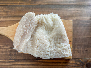 Fresh pieces of beef tripe ready for cooking in kitchen on wooden cutting board