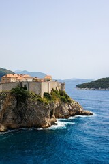 view of the historic Dubrovnik city walls on rocky cliff overlooking the Adriatic Sea in Croatia