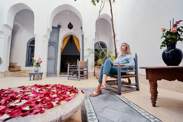 Traveling by Morocco. Happy young woman in traditional riad interior in medina.