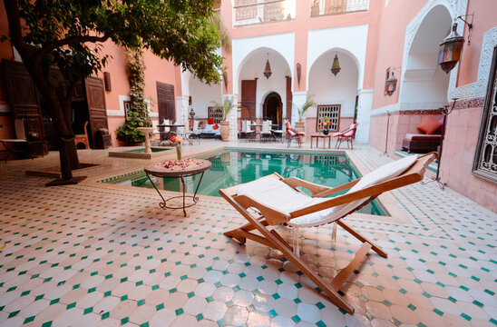 Oriental hospitality. Traveling by Morocco. Relaxing in festive moroccan traditional riad interior with swimming pool.