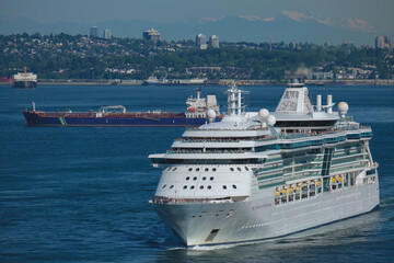 Modern cruiseship cruise ship ocean liner Brilliance sail away departure from port of Vancouver, British Columbia for Alaska summer cruising on sunny day with city skyline Lions Gate Bridge