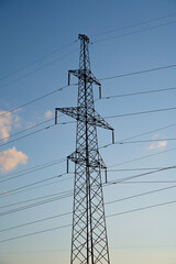 Power lines with wires on blue sky with clouds