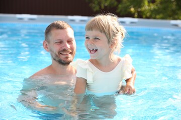 Fototapeta premium Happy father having fun with his daughter in swimming pool