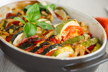 prepared baked zucchini and tomatoes in circles in a ceramic form, vegetable snack
