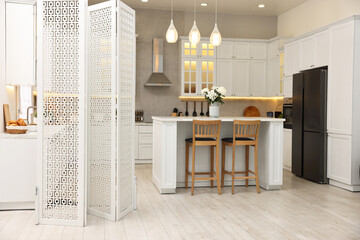 Stylish kitchen interior with folding screen and table