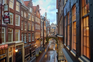 Fototapeta premium Narrow canal reflecting warm light from traditional brick buildings at twilight in amsterdam, netherlands