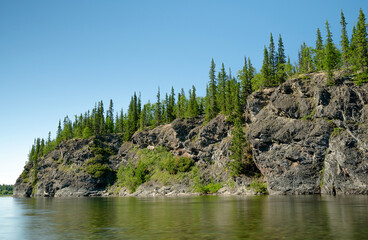 Rock and forest near the river on a sunny day