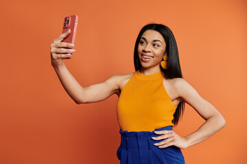 Smiling woman captures a joyful moment with her phone in a colorful setting.