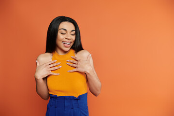 A woman expresses happiness and self love against a bold backdrop.