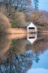 Obraz premium A boathouse sits on Rydal Water lake in Autumn in the Lake District National Park