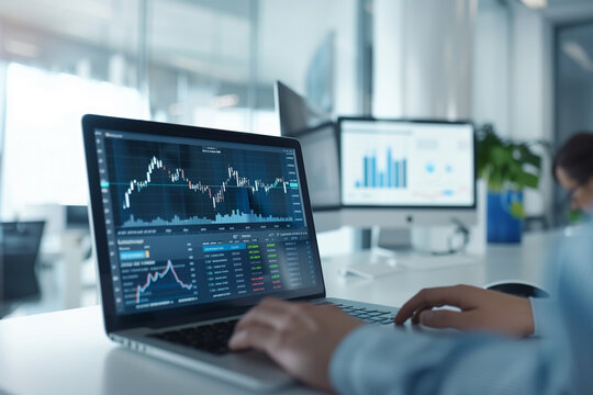 A businessman trader analyzing investment charts on a laptop computer screen.