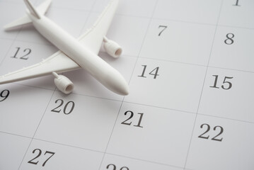 Airplane on white blank calendar background copy space. Annual leave travel period for relaxation...
