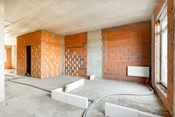 Built structure construction site of residential apartment building. Interior in progress to new house red brick wall