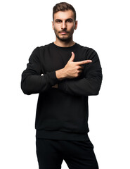 Fototapeta premium Young man in a black sweatshirt pointing to the side with a confident expression