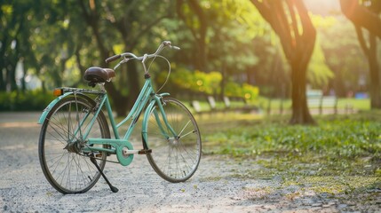 Fototapeta premium A vintage bicycle stands along a shaded path in a park, with dappled sunlight creating an inviting, serene setting.