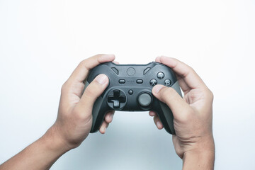 Fototapeta premium Hand holding a gamepad or joystick against a white background with empty copy space for text or advertisement