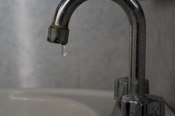 Llave del fregadero abierto goteando agua