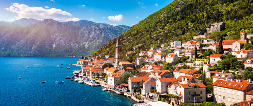 View of the historic town of Perast at famous Bay of Kotor on a beautiful sunny day with blue sky and clouds in summer, Montenegro. Historic city of Perast at Bay of Kotor in summer, Montenegro.