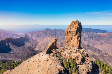 Roque Nublo and Pico de Teide in the background on Gran Canaria Island, Spain. Panoramic view of Roque Nublo sacred mountain, Roque Nublo Rural Park, Gran Canary, Canary Islands, Spain.