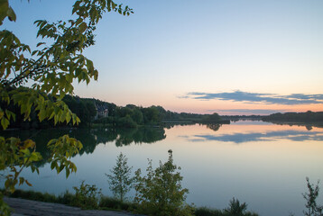 Sunset on the lake, and yellow leaves of trees. Natural autumn background.