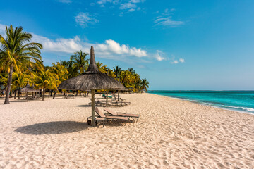 Beach with palm trees and umbrellas on Le morne Brabant beach in Mauriutius. Tropical crystal ocean with Le Morne beach and luxury beach in Mauritius. 