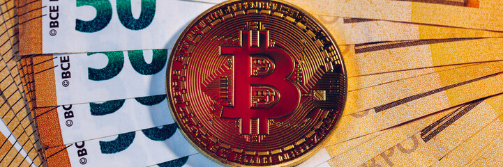 Golden bitcoin over Euro money. Bitcoin cryptocurrency. Crypto currency concept. Bitcoin with euro bills. Bitcoins stacked on euro banknotes.