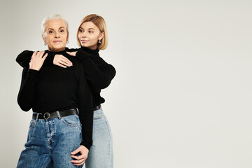A mature woman embraces her adult daughter in a chic, cozy setting.