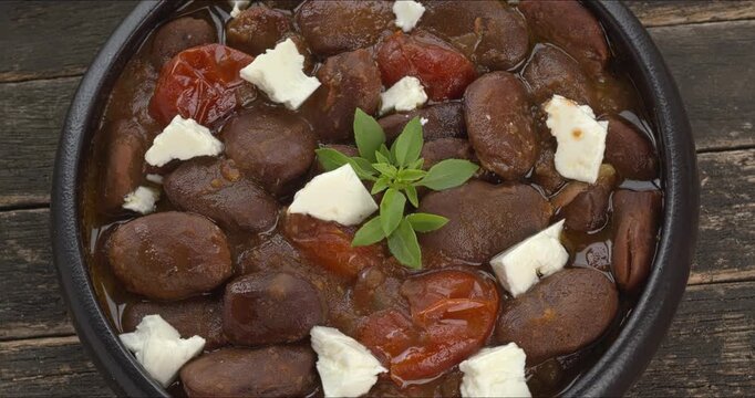 Ful Mudammas (Medammes) topped with feta cheese in a bowl. Egyptian dish made of dried fava bean, onion, garlic, tomatoes, and olive oil.