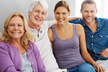 Obraz premium Happy, family and portrait or together on sofa for support, love and trust or care in home. Woman, man and senior people in lounge or living room for relationship, bonding and smile for retirement