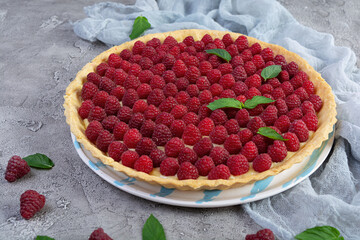 Delicious tart with custard and raspberries. Raspberry cake decorated with mint leaves