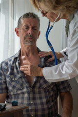 Physician, doctor examines a patients chest with a stethoscope at a  heart clinic check up