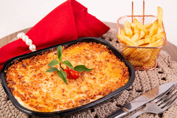 Lasagna on a plate with cheese and fries, gastronomy and cooking