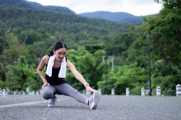 Young beautiful Asian woman doing stretching exercise in outdoor park.