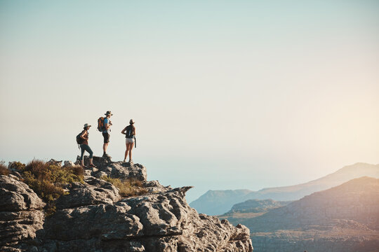 Friends, hiking and mountain on cliff outdoor for fitness travel, adventure view or backpack journey in summer. People, backpacking and trekking together for cardio exercise, rock climbing and health