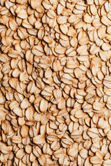 Fototapeta premium Macro shot of the texture of rolled oats highlighting the flattened light brown grains with intricate layers 