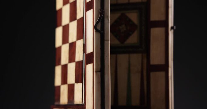 Detailaufnahme Rotation eines Backgammon und Schach Spielbretts vor schwarzem Hintergrund