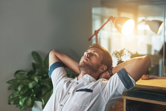 Night, relax and business with man, tired and sleeping with finished project, overworked and burnout. Hands behind head, employee and graphic designer in modern office, exhausted and stretching