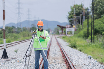 Surveyor builder site engineer with theodolite total station at Railway site outdoors during surveying work