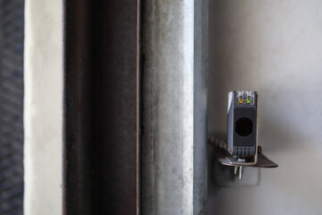 Garage gate sensor mounted on wall. Close up of photoelectric sensor with connected to overhead...