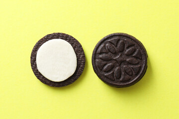 Tasty sandwich cookies with cream on green background, top view
