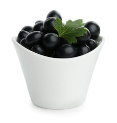 Bowl of ripe blackcurrants and green leaf isolated on white