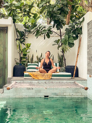 Woman in a black swimsuit relaxing at the pool