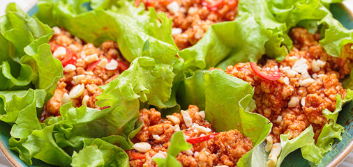 Lettuce wraps filled with a savory mixture of minced meat, herbs, and spices, creating a flavorful...