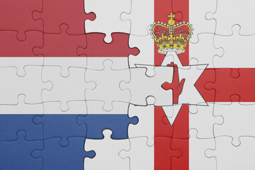 puzzle with the colourful national flag of northern ireland and flag of netherlands.