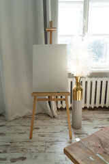 This bright art studio features a large table, a comfy chair, and colorful artwork, fostering creativity