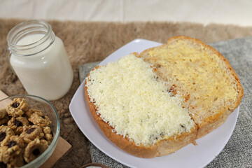 Bread with cheese, sweetened condensed milk, and butter. With white milk and snack on a table for breakfast	
