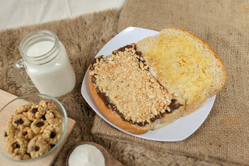 Bread with peanut, chocolate and butter spread on a table for breakfast	
