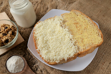 Bread with cheese, sweetened condensed milk, and butter. With white milk and snack on a table for breakfast	
